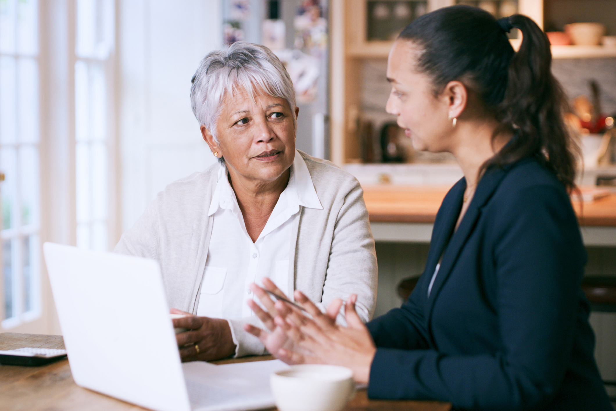 Two women having a discussion with laptop.