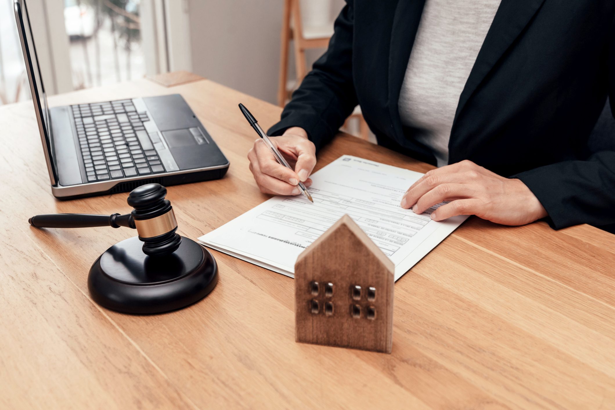 Businessperson signing documents at a desk.